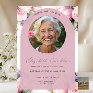 Könnte beinhalten: Eine Trauerkarte mit einem Foto einer lächelnden Frau, umgeben von rosa floralen Akzenten. Der Text lautet "Celebrating the Life of Elizabeth Gualdeni" mit Datums- und Ortsangaben. Eine Kerze und Blumen sind im Hintergrund.