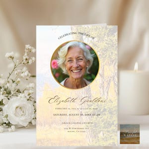 May include: A memorial card with a photo of a smiling woman in a gold-rimmed circle. The card reads "Celebrating the Life of Elizabeth Gualdeni" with dates and location details. The background has a soft, natural landscape.