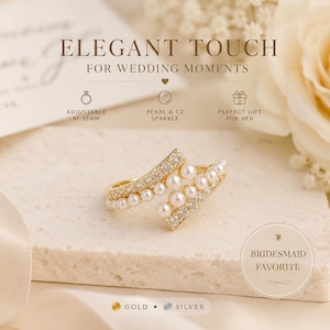 Könnte beinhalten: Ein goldfarbener Ring mit einzigartigem Design, besetzt mit Perlen und CZ-Funkeln. Der Ring ist von 51-55 mm verstellbar. Der Text auf dem Bild lautet "Elegant Touch for Wedding Moments" und wird als Favorit der Brautjungfern bezeichnet.