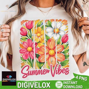 May include: White t-shirt featuring a vibrant floral design with pink, orange, yellow, and white flowers. The words "Summer Vibes" are written in a cursive font. The design includes green leaves and vertical white stripes.