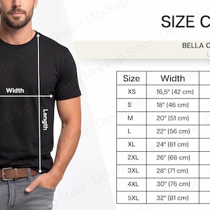 以下が含まれることがあります： 黒色のBella Canvas 3001ユニセックスTシャツとサイズチャート。XSから5XLまでのサイズで、cm単位の測定値が表示されています。モデルはTシャツとグレーのジーンズを着用しています。
