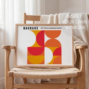 May include: A framed print featuring a Bauhaus design with geometric shapes in red, orange, and yellow. The print includes the text "BAUHAUS" and "S&ouml;tterlin Badenerstrasse". The artwork is displayed on a wooden chair with a woven seat.