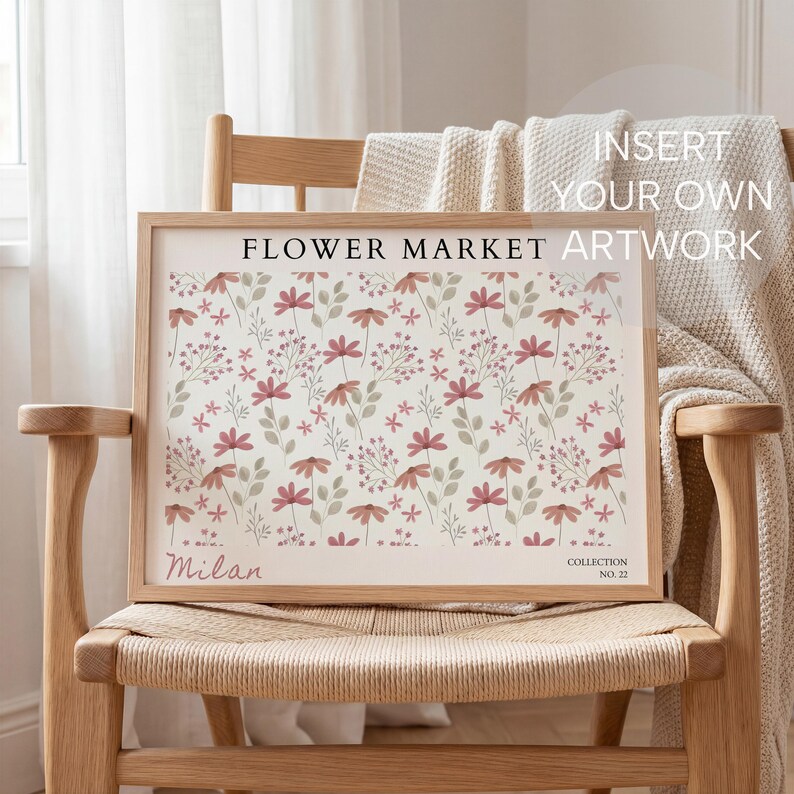 May include: A framed floral artwork with a light wood frame. The print features a repeating pattern of pink flowers and green leaves on a cream background. Text at the top reads "FLOWER MARKET ARTWORK". The artwork is displayed on a wooden chair.