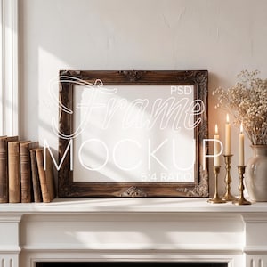 May include: A dark brown ornate picture frame mockup with a white interior, resting on a white mantel. The frame is flanked by old books, brass candle holders with lit candles, and a vase of dried flowers.