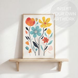 May include: A framed floral art print featuring stylized flowers in orange, yellow, blue, and red. The artwork is displayed on a light wooden shelf against a white wall. The text "INSERT YOUR OWN ARTWORK" is in the upper right corner.