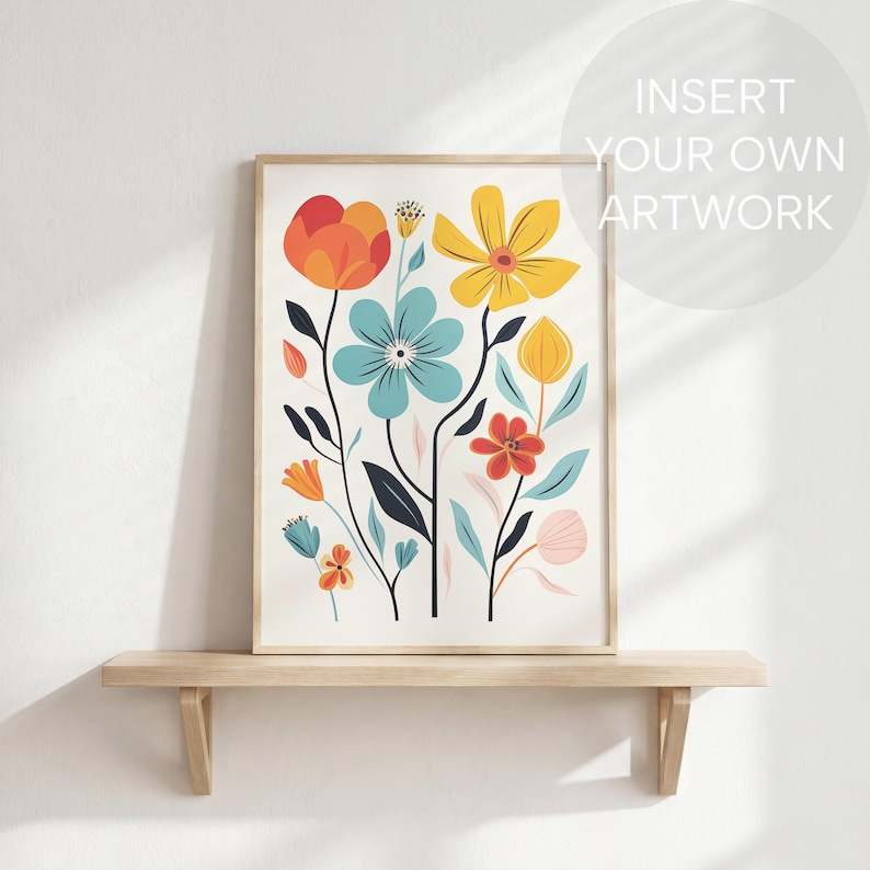 May include: A framed floral art print featuring stylized flowers in orange, yellow, blue, and red. The artwork is displayed on a light wooden shelf against a white wall. The text "INSERT YOUR OWN ARTWORK" is in the upper right corner.