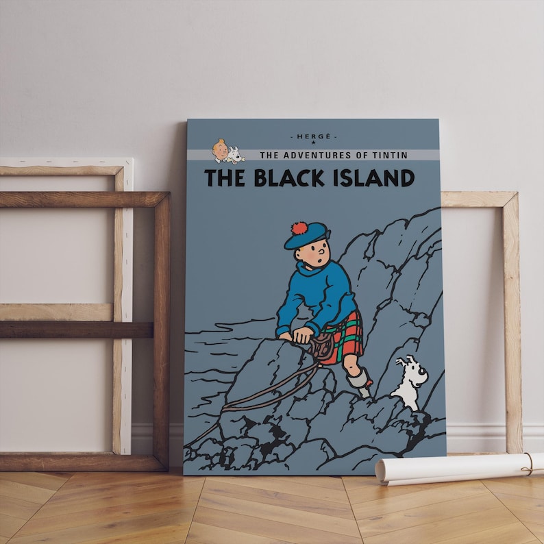 May include: A framed print of "The Black Island" from The Adventures of Tintin. The artwork features Tintin in a blue sweater and kilt, climbing a rocky cliff with his dog Snowy. The title is displayed in bold white letters.