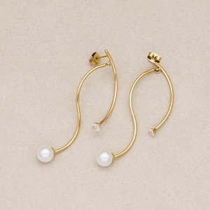 May include: A pair of gold-toned earrings featuring a curved, S-shaped wire design. Each earring is accented with a single white pearl at the bottom end and a small, clear, round-cut gemstone at the top end, complete with a standard post-back closure.