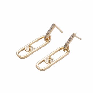 May include: A pair of gold-toned earring findings featuring a post with a small cup and peg for mounting a stone, attached to a dangling rectangular link. The top bar of each earring is encrusted with a row of small, clear, sparkling crystals.