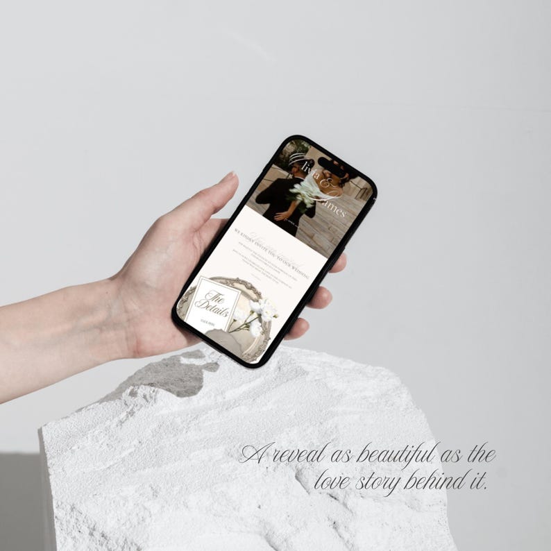 May include: A black smartphone displaying a digital wedding invitation on its screen. The screen shows the text Livia & James, The Details, and a floral graphic. The interface features a soft color palette with white and beige tones throughout.