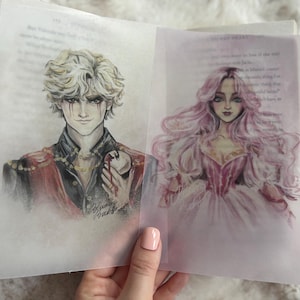 Puede incluir: Dos ilustraciones sobre papel translúcido, probablemente insertos de libros. Una representa a un hombre con cabello claro, maquillaje de ojos oscuro y una chaqueta roja y negra. La otra muestra a una mujer con largo cabello rosa y un vestido rosa.