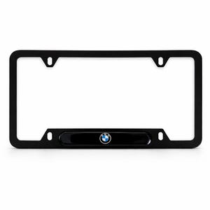 Może przedstawiać: Czarna ramka tablicy rejestracyjnej z logo BMW. Ramka jest prostokątna z zaokrąglonymi rogami i otworami montażowymi. Logo BMW to niebiesko-białe koło z czarną obwódką.