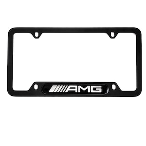May include: Black license plate frame featuring the white "AMG" logo. The frame is rectangular with rounded corners and four mounting holes. The AMG logo is positioned centrally at the bottom.