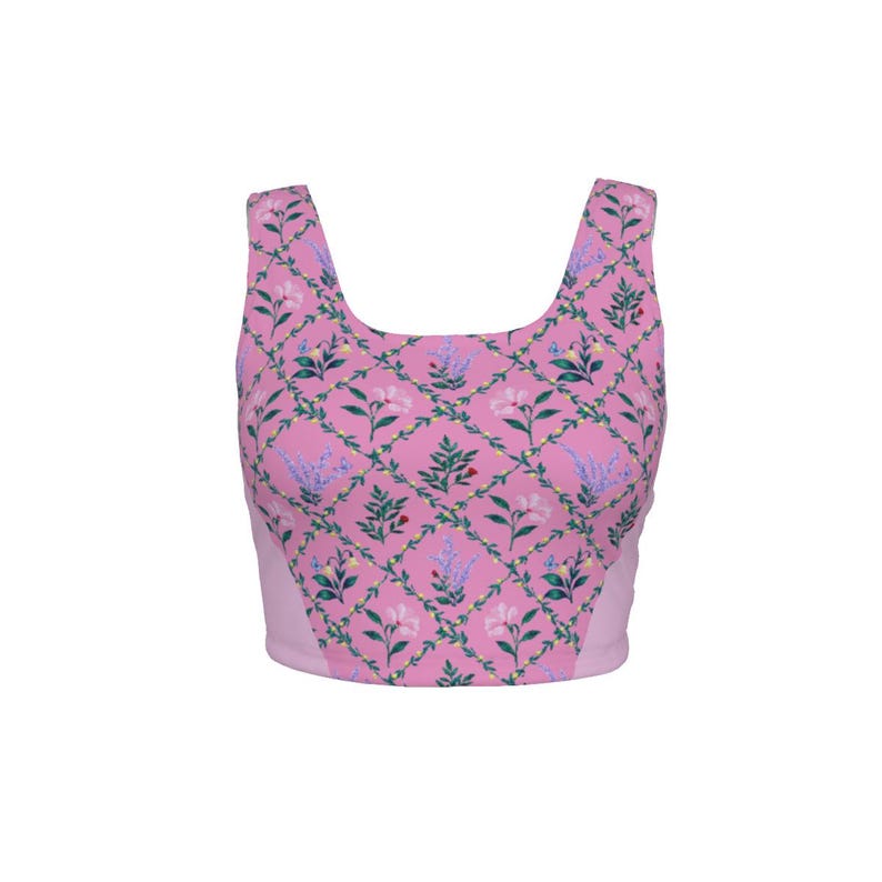 Peut inclure: Un haut court sans manches rose avec un motif en losanges r&eacute;p&eacute;titif. Le design comprend de petites vignes vertes, des brins de lavande violet clair et des fleurs blanches avec des feuilles vertes centr&eacute;es dans chaque losange de la grille.