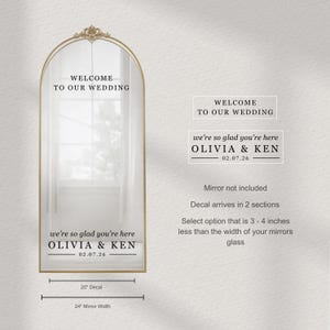 May include: A decorative gold-framed mirror with the text "WELCOME TO OUR WEDDING". Below, it reads "we're so glad you're here OLIVIA & KEN 02.07.26". The image also shows a separate decal with the same text.