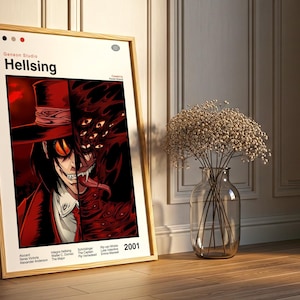 May include: A framed poster featuring artwork from the anime series Hellsing. The artwork depicts a character in a red hat and coat, with a split face revealing a monstrous form. The poster is set against a white background with the title "Hellsing" and the year 2001.