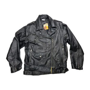 Könnte beinhalten: Eine schwarze Motorradjacke aus Leder mit breitem Reverskragen, asymmetrischem Frontreißverschluss und einem Taillengürtel mit Schnalle. Die Jacke verfügt über mehrere silberfarbene Reißverschlusstaschen, eine kleine Pattentasche und ein Etikett.