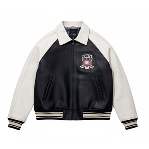 Back view of black and white Avirex USA leather varsity jacket featuring oversized AVIREX USA lettering, embroidered American crest, striped ribbed waistband, vintage bomber style