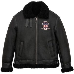 May include: Black leather jacket with a shearling collar and lining. Features a zip-up front, two front pockets, and a patch on the chest with the text "AVIREX". Includes buckle details at the waist and cuffs. A classic outerwear piece.
