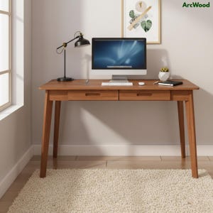 May include: A wooden desk with two drawers, a computer, and a black desk lamp. The desk is made of light brown wood and has a minimalist design. A white rug is on the floor in front of the desk. The brand name "ArcWood" is visible in the top right corner.