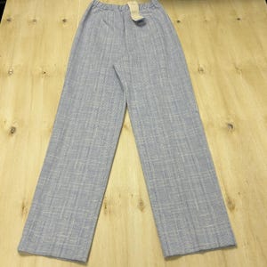 May include: Light blue wide-leg pants with a subtle plaid pattern. The pants have a comfortable, relaxed fit and a high waist. A tag is attached to the waistband. The fabric appears to be lightweight, suitable for warmer weather.