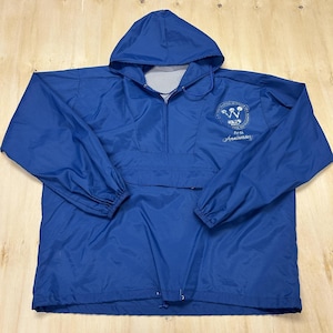 May include: A royal blue pullover windbreaker jacket with a hood, long sleeves with elastic cuffs, and a drawstring hem. The front features a white graphic logo with the text "Celebrating 40 Years of Excellence" and "40th Anniversary" printed on the chest.