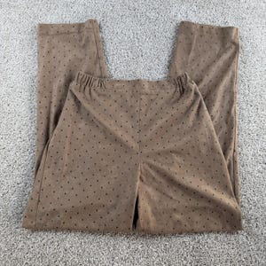 May include: A pair of tan trousers featuring an elasticated waistband and a consistent pattern of small, dark brown studs distributed across the entire surface of the fabric. The trousers have a straight-leg cut and a smooth, matte texture.