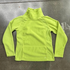 May include: A lime green fleece pullover featuring a high mock neck collar, long sleeves, and vertical ribbed side panels. The garment includes a front kangaroo pocket and a small embroidered logo near the bottom hem, constructed from soft fabric.
