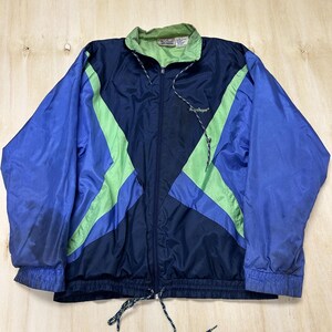 May include: A navy blue, royal blue, and lime green windbreaker jacket featuring a full-length front zipper, a high collar with a light green interior lining, long sleeves with elastic cuffs, and a drawstring hem with adjustable toggles.