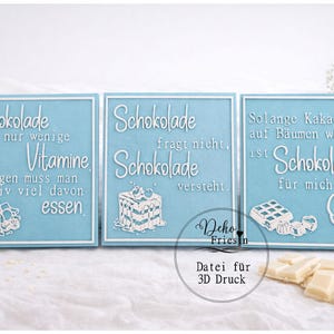 以下が含まれることがあります： チョコレートに関する白いテキストが書かれた、3つの水色の装飾看板。看板には白い縁取りがあり、「Schokolade」と「Obst」の文字が書かれています。看板には、チョコレートやその他のお菓子の白いイラストも描かれています。