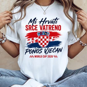 May include: White t-shirt with a Croatian flag design. The shirt features the text "Mi Hrvati SRCE VATRENO PONOS VJEČAN WORLD CUP 2026" in blue and red. The design includes a Croatian coat of arms.