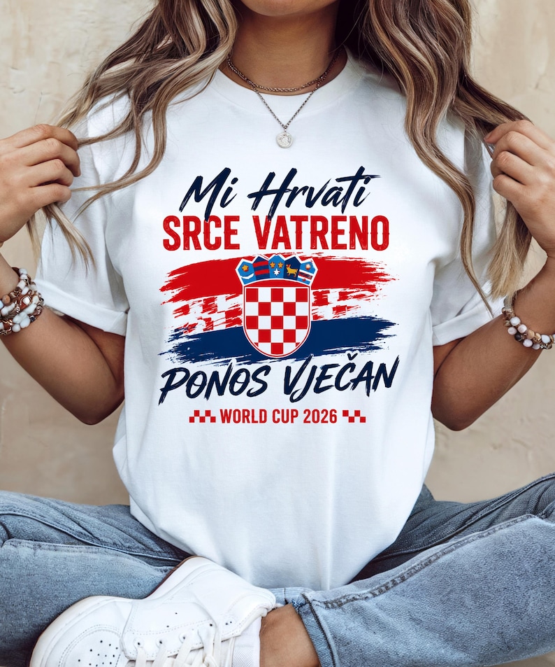 May include: White t-shirt with a Croatian flag design. The shirt features the text "Mi Hrvati SRCE VATRENO PONOS VJEČAN WORLD CUP 2026" in blue and red. The design includes a Croatian coat of arms.