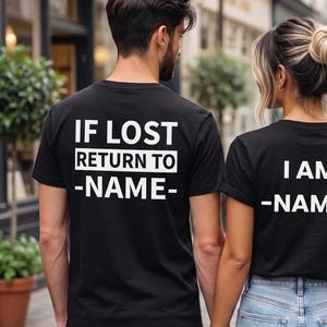 Könnte beinhalten: Zwei schwarze T-Shirts mit kurzen Ärmeln und weißem Text. Das linke Shirt trägt die Aufschrift IF LOST RETURN TO -NAME-. Das rechte Shirt trägt die Aufschrift I AM -NAME-. Beide Shirts werden mit hellblauen Jeans kombiniert.