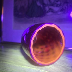 Ruby Red glass shade under black light showing bright orange glow of inside UV glass layer