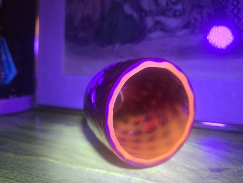 Ruby Red glass shade under black light showing bright orange glow of inside UV glass layer