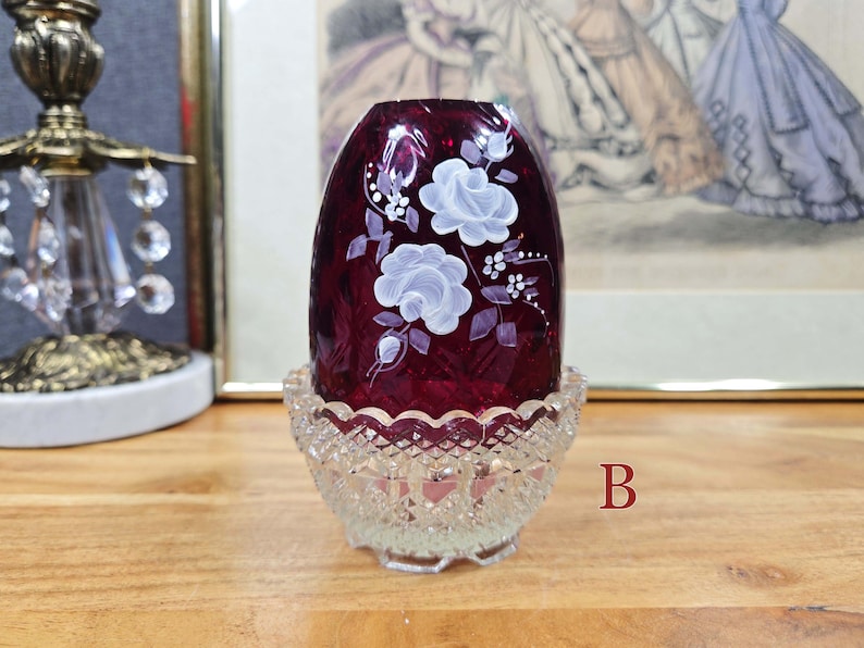 Fairy lamp labeled B with red glass shade, white painted flowers, and clear pressed glass base