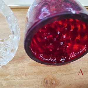 Underside of red glass shade labeled A showing white painted Fleming signature next to the clear glass base