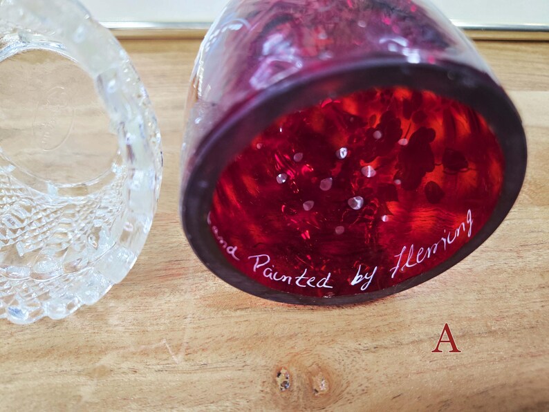 Underside of red glass shade labeled A showing white painted Fleming signature next to the clear glass base