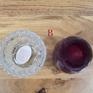 Top view of fairy lamp B with clear pressed glass base and red glass shade separated on wood surface