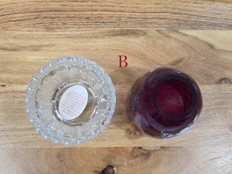Top view of fairy lamp B with clear pressed glass base and red glass shade separated on wood surface