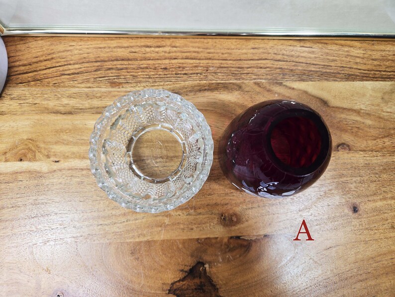 Top view of clear pressed glass base and red glass shade labeled A placed side by side on a wood surface
