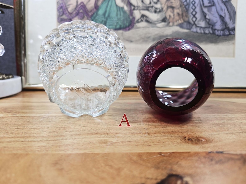 Bottom view of clear pressed glass base and opening of red glass shade labeled A placed side by side