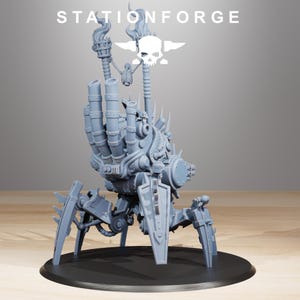 Pode incluir: Uma figura mec&acirc;nica cinza detalhada com uma estrutura semelhante a uma m&atilde;o, m&uacute;ltiplos tubos e um escudo. A figura tem quatro pernas e &eacute; montada em uma base circular preta. O texto "STATIONFORGE" e um logotipo de caveira s&atilde;o vis&iacute;veis.