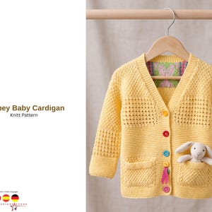 Puede incluir: Un cárdigan de bebé amarillo tejido con cuello en V, dos bolsillos y botones coloridos. Un pequeño conejito de peluche está en un bolsillo. El texto "Canbey Baby Cardigan Knitt Pattern" está a la izquierda.