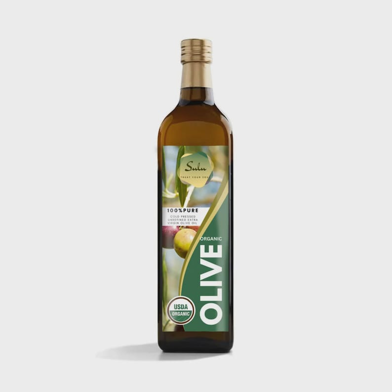 Puede incluir: Una botella alta y rectangular de aceite de oliva con tap&oacute;n dorado y etiqueta verde y blanca. La etiqueta presenta la palabra "OLIVE" en letras blancas grandes y las palabras "100% Pure" y "Organic". La botella contiene un l&iacute;quido verde claro.
