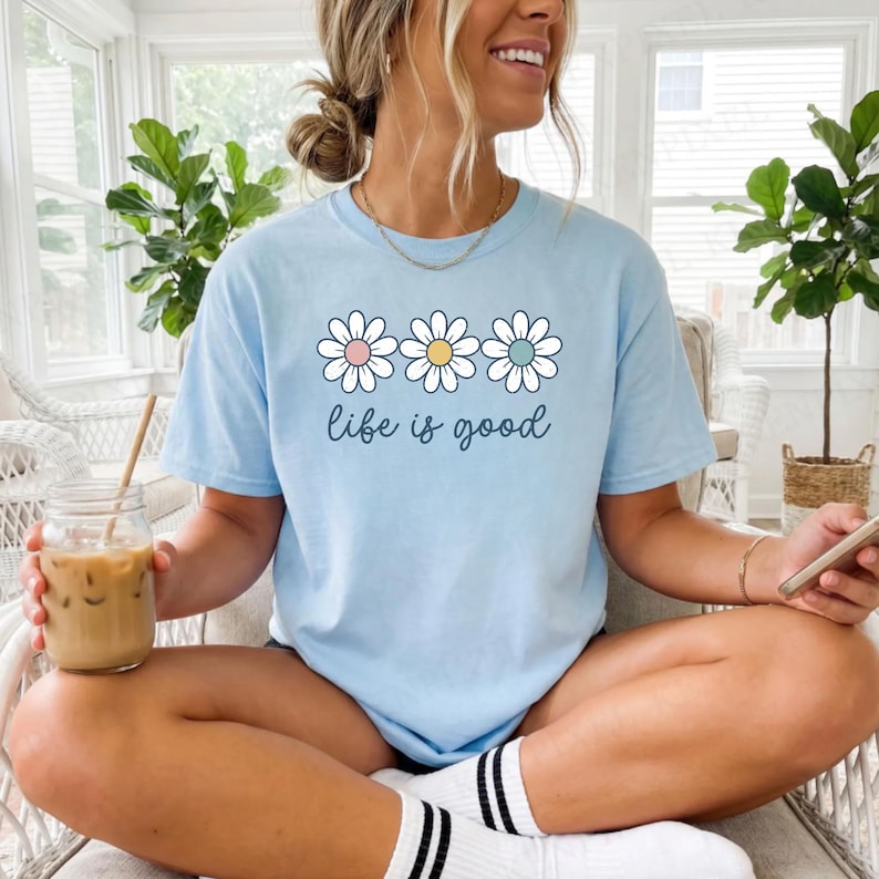 May include: A white ceramic mug with a black handle and the text "But First, Coffee" in a handwritten style. The mug is on a white surface. The mug is approximately 4 inches tall.