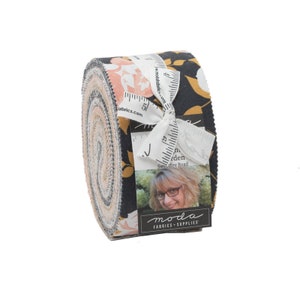 May include: A roll of fabric featuring a floral print in shades of pink, yellow, and grey on a black background. The fabric is rolled up and tied with a white ribbon. The label reads "Sweetfire Road" and "moda fabrics + supplies".