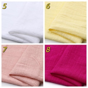 May include: A collection of four fabric swatches labeled 5, 6, 7, and 8. The swatches feature a textured, woven material in solid colors: white, pale yellow, soft dusty pink, and vibrant magenta. Each piece of fabric is folded to show texture.