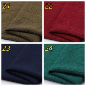 May include: A collection of four fabric swatches labeled 21, 22, 23, and 24. The swatches feature a textured weave in olive green, deep red, dark navy blue, and forest green. Each piece of fabric is folded to show the material's surface.