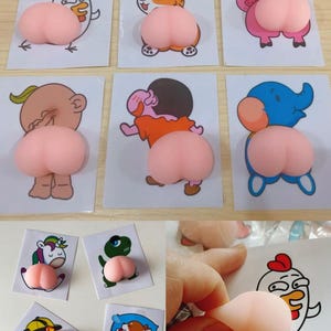 Puede incluir: Una colección de artículos novedosos con ilustraciones de personajes y animales de dibujos animados, cada uno emparejado con una forma rosa y redondeada. Los diseños incluyen un pollo, un corgi, un cerdo y otros personajes.